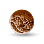 A round brown silicone baking mat featuring a relief design of mountains, trees, and a rising sun, shown on a clean white background with a soft drop shadow.