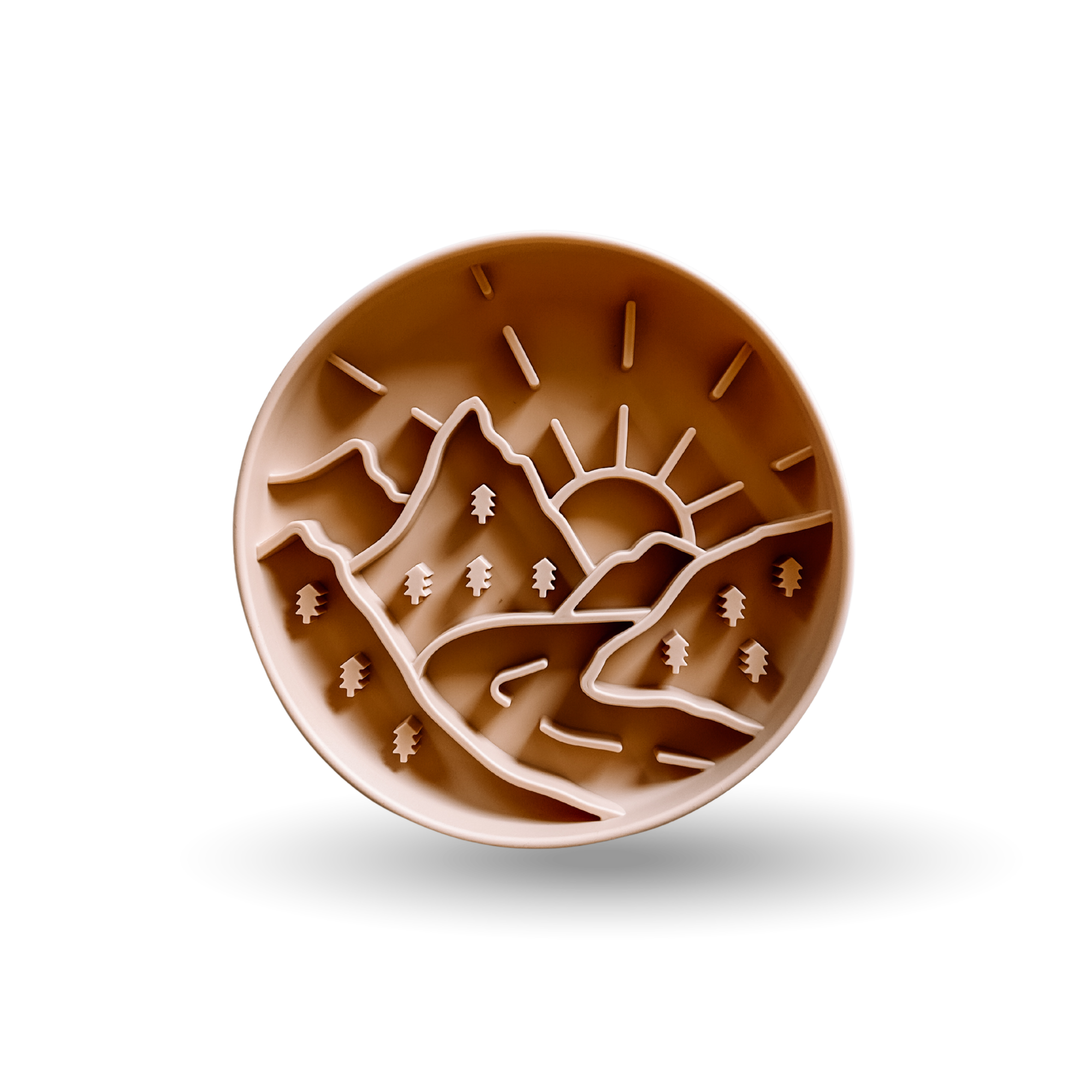 A round brown silicone baking mat featuring a relief design of mountains, trees, and a rising sun, shown on a clean white background with a soft drop shadow.