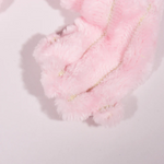Close-up of pink fluffy material with gold thread on a light pink background