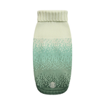 A knit pet sweater with a vertical gradient transitioning from cream at the top to mint green and dark forest green at the bottom, featuring a ribbed collar and a small circular logo patch near the hem.