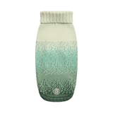 A knit pet sweater with a vertical gradient transitioning from cream at the top to mint green and dark forest green at the bottom, featuring a ribbed collar and a small circular logo patch near the hem.