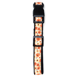 A pet collar with a black plastic buckle and a woven fabric strap featuring a pattern of orange and yellow flowers on a cream background.