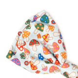 A light blue ribbed fabric accessory, likely a headband or hair tie, featuring a colorful pattern of cartoon mushrooms and small flowers in red, orange, green, blue, and pink.