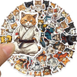 Sticker of a cat in a martial arts outfit held over a collection of similar cat-themed stickers.