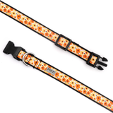 A dog collar with a repeating orange and yellow floral pattern on a cream background, featuring black plastic hardware and a silver metal ring.