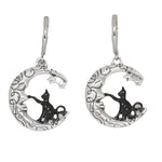 Silver earrings with cat designs on a white background
