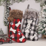 Two Christmas stockings with plaid patterns and animal designs against a snowy background.