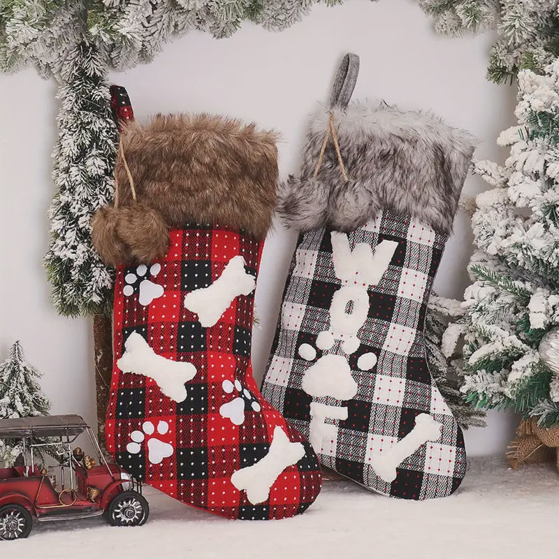 Two Christmas stockings with plaid patterns and animal designs against a snowy background.