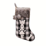 Christmas stocking with plaid pattern, gray fur trim, and paw print design on a white background