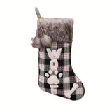 Christmas stocking with plaid pattern, gray fur trim, and paw print design on a white background