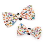 Three colorful mushroom-patterned bow ties on a white background