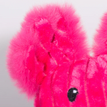 Close-up of a bright pink plush toy with black eyes on a light gray background