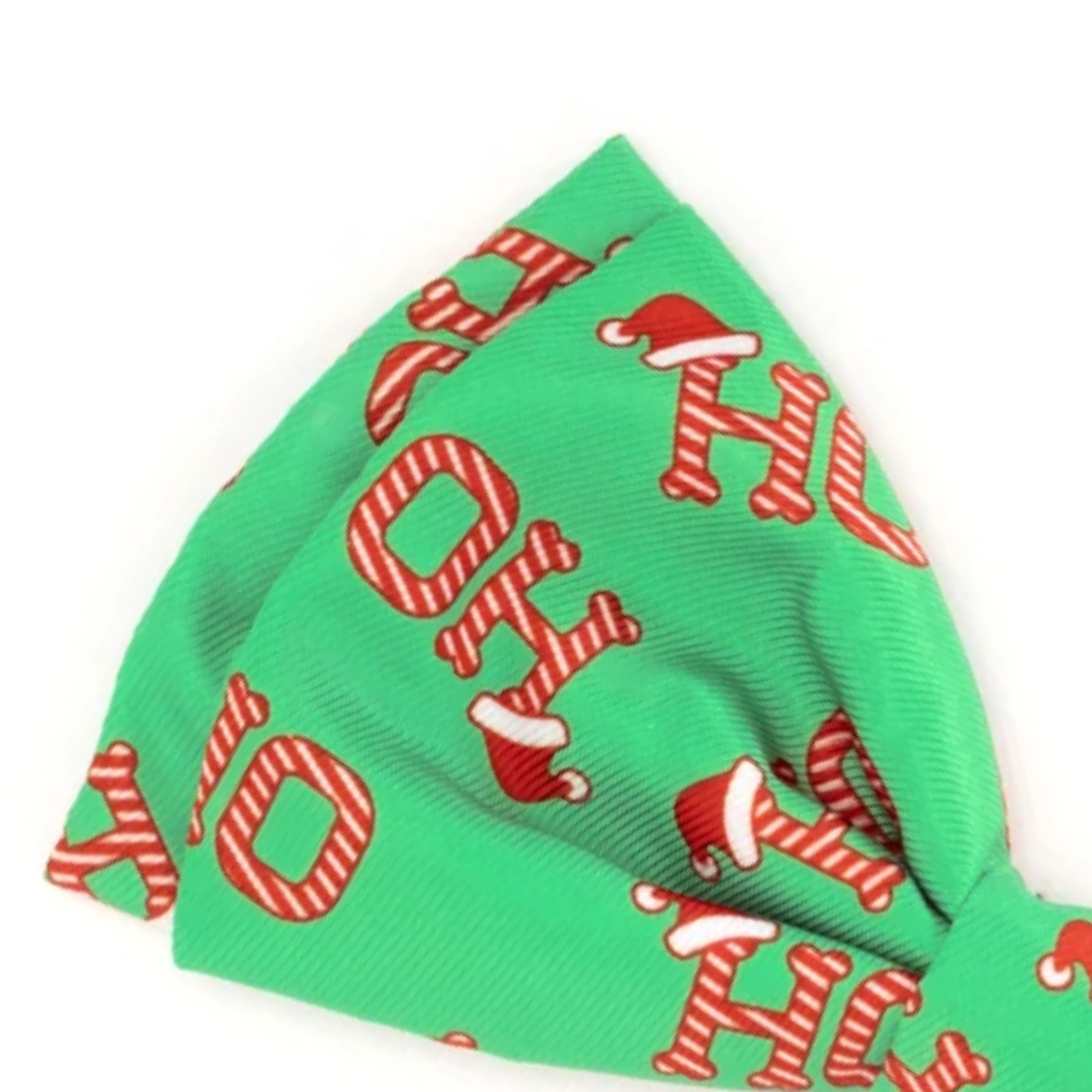 A green pet bandana featuring a festive holiday print with red and white striped 'HO HO HO' letters and Santa hats, shown on a plain white background.