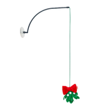 A Christmas mistletoe wall-mounted toy or decoration with a black curved arm, green hanging cord, white suction-style wall mount, green mistletoe leaves, white dots, and a red bow on a plain white background.