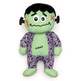 Plush toy resembling a character with green skin, black hair, and purple patterned outfit on a white background