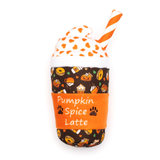 A plush toy shaped like a Pumpkin Spice Latte cup, featuring a dark brown patterned body with orange, yellow, and white fall-themed illustrations, an orange sleeve with white text reading 'Pumpkin Spice Latte' and small paw prints, a white whipped cream top with orange spots, and an orange-and-white striped straw, all on a plain white background.