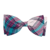 A pre-tied bow tie featuring a multicolor plaid pattern with teal, magenta, and light pink tones, displayed flat against a solid white background.