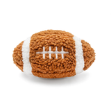 A plush football-shaped dog toy made of textured brown fleece with white stripes and white embroidered laces, photographed on a clean white background.
