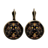 Pair of earrings with a black cat design on a white background