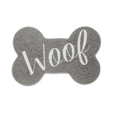 Gray bone-shaped mat with 'Woof' text on a white background