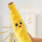 Plush banana toy with a face held by a hand against a light background