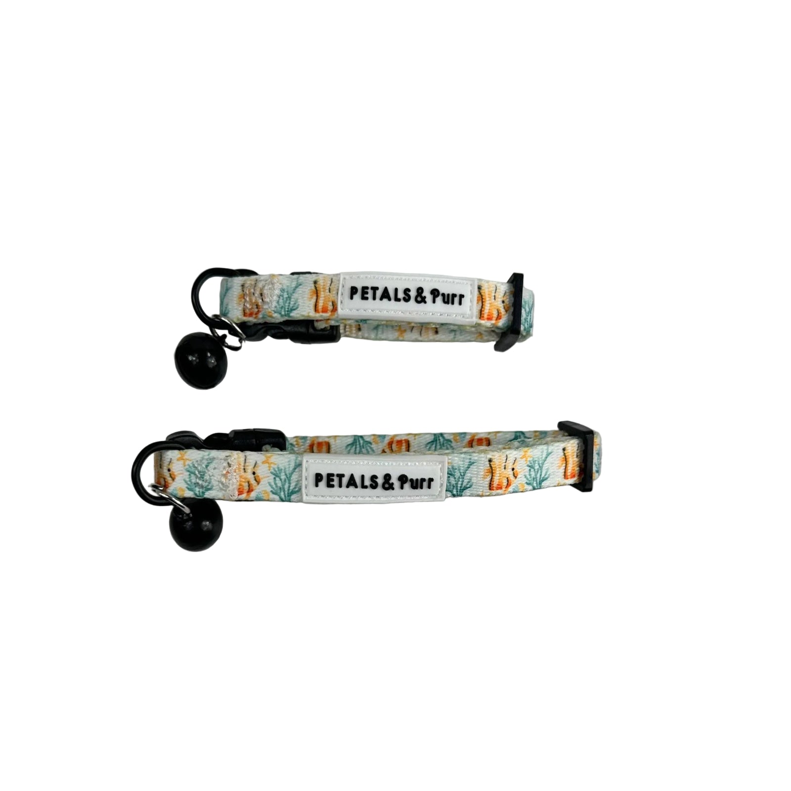 Two fabric pet collars with black bells and black plastic hardware, laid flat on a light whitewashed wood background. The collars have a white base with a colorful pattern of orange and yellow flowers, green leaves, and blue sea plants, and a white label that reads 'PETALS & Purr'.