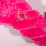 Close-up of a pink towel with a gold ring detail on a white background