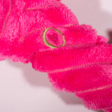 Close-up of a pink towel with a gold ring detail on a white background