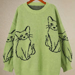 Green sweater with black cat illustrations on a beige background