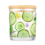 Candle with cucumber slices and floral design on a white background