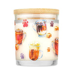 Candle with glass container and wooden lid featuring illustrations of hot beverages and paw prints on a white background.