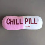 Pillow shaped like a pill with 'CHILL PILL' text on a gray background