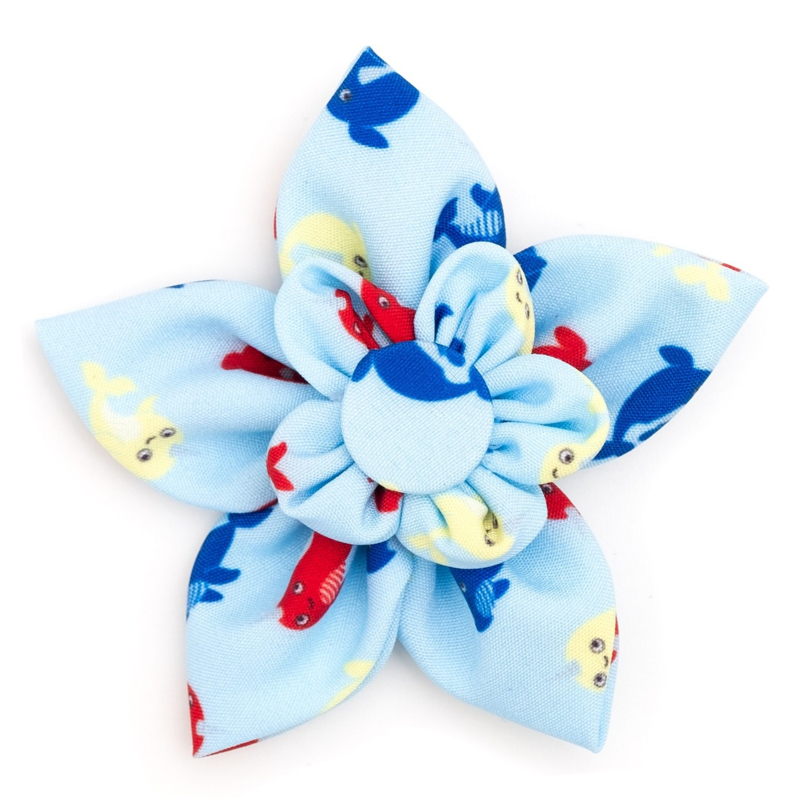 A fabric flower hair clip with six petals in light blue, featuring a pattern of red and yellow fish with small cartoon eyes, and a matching blue and white ruffled center.