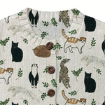 Textile with animal pattern including cats, squirrels, and leaves on a white background
