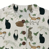 Textile with animal pattern including cats, squirrels, and leaves on a white background