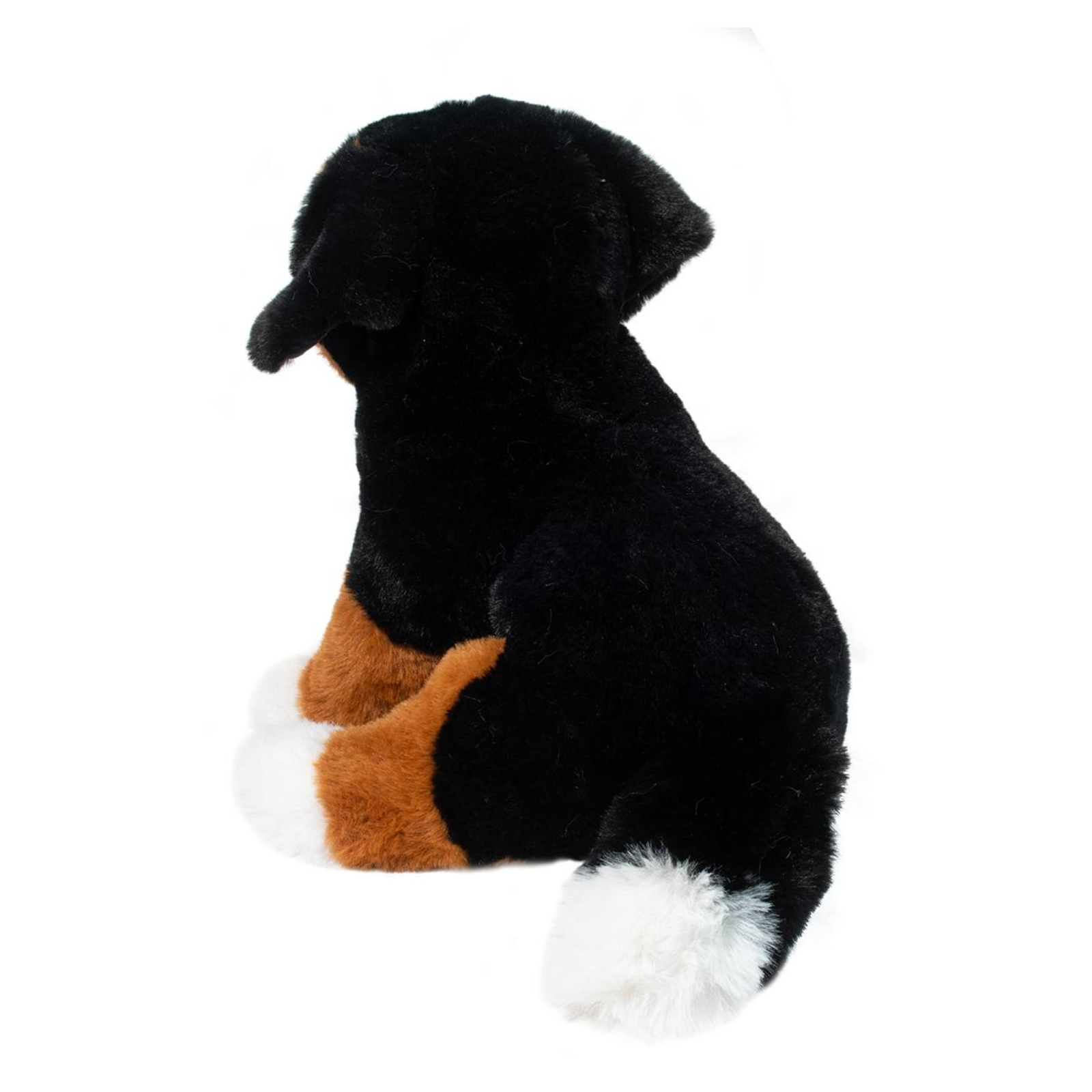Plush toy resembling a black, brown, and white dog on a white background