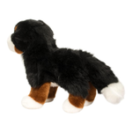 Plush toy dog with black, brown, and white fur on a white background