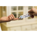 Hand applying a tube of Olay product to another hand with a blurred background