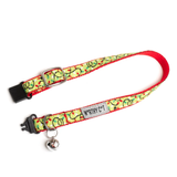 A pet collar with a red and green patterned fabric strap, a silver metal buckle, a silver metal D-ring, and a small silver bell. A fabric label on the collar reads 'MY RICH COT'.