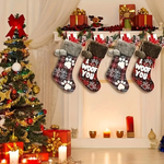 Decorative stockings with paw prints and 'I woof you' text hanging by a Christmas tree and fireplace.