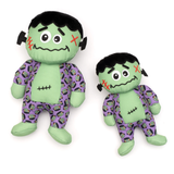 Two plush toys resembling Frankenstein characters with green skin and purple patterned outfits on a white background.