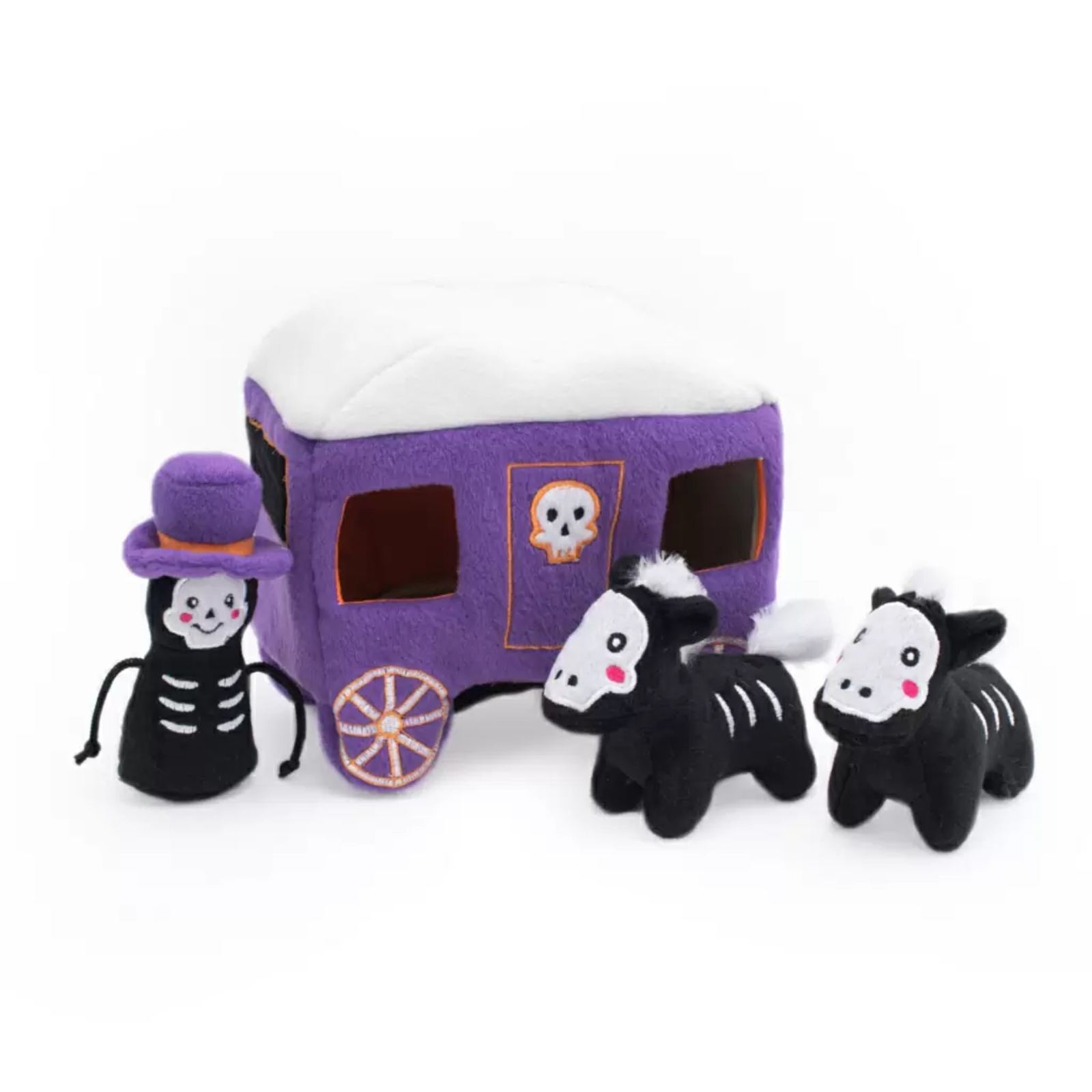 A Halloween-themed plush dog toy set featuring a purple and white camper trailer, a skeleton character wearing a purple hat, and two black-and-white skeleton cows, all photographed on a clean white background.