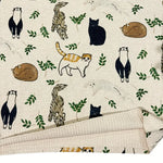 Patterned fabric with cartoon animals and leaves on a beige background