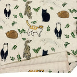 Patterned fabric with cartoon animals and leaves on a beige background