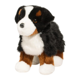 Plush toy dog with black, brown, and white fur on a white background