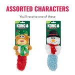 Two KONG Kickaroo plush dog toys on retail cards against a white background, with large red text reading 'ASSORTED CHARACTERS' above. One toy is a brown reindeer with green antlers and a green scarf, and the other is a white snowman with a black hat, orange nose, red scarf, and blue fluffy tail.