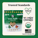 Package of Love Puffs Jingle Bells dog treats with branding and certification logos on a green background