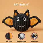 A black bat-shaped dog toy with orange inner ears and a squeaky core, shown on a warm beige background with text reading 'BAT BALL 4"' and three circular feature callouts below.