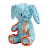 A plush stuffed bunny toy in light blue fabric with a repeating bunny and carrot print, orange trim along the arms and legs, and embroidered facial features on a plain white background.