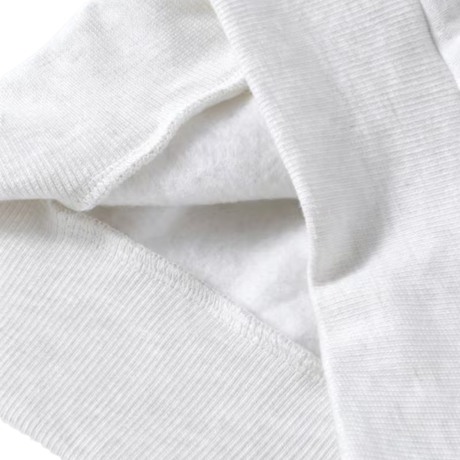 Close-up of a white ribbed knit fabric, showing the texture and folds of a garment or textile.